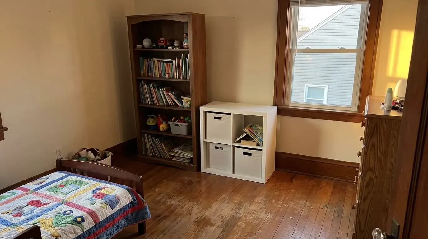 A child's bedroom with a tall wooden bookcase and a white cube organizer.